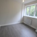 Minimalist empty room with large window and radiator.