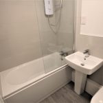 Modern bathroom with shower, sink, and toilet