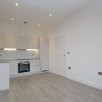 Modern kitchen with white cabinets and appliances.