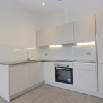 Modern kitchen with white cabinets and oven.