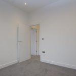 Empty room with grey carpet and open door.