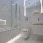 Modern marble bathroom with bath and shower.