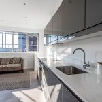 Modern kitchen with grey sofa and marble countertop