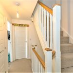 Hallway with stairs and closed white doors.