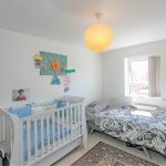 Cosy baby nursery and bedroom with crib, bed, decorations.