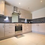 Modern kitchen with grey cabinets and appliances.