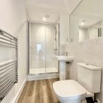 Modern bathroom with shower and wooden floor.