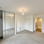 Unfurnished bedroom with wardrobe and ensuite bathroom.