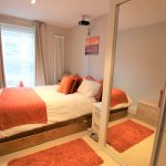 Cosy bedroom with orange accents and mirror