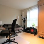 Home office with desk chair and exercise bike