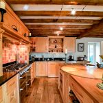 Rustic kitchen with wooden beams and modern appliances.
