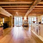 Rustic kitchen with wooden beams and stone walls.