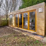 Garden studio with wooden exterior and glass doors.