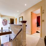Modern hallway with open door and artwork on wall.
