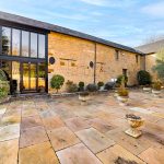 Stone courtyard with plants and large building windows.