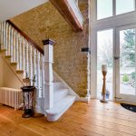 Spacious hallway with stairs and glass door view.