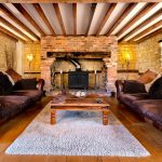 Rustic living room with exposed beams and fireplace.