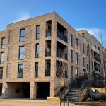 Modern brick apartment building with blue sky.