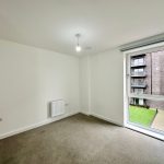 Empty room with window overlooking courtyard.