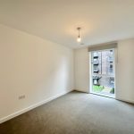 Empty room with carpet and window view.