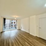 Spacious modern room with wooden flooring and balcony