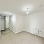 Empty white room with wardrobe and radiator