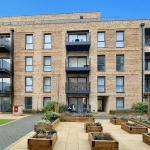 Modern apartment building with balconies and garden boxes.