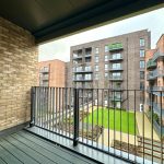 Balcony view of modern apartment complex and courtyard.