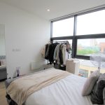 Modern bedroom with large window and city view.