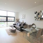 Modern living room with grey furniture and window view.