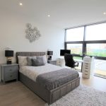 Modern bedroom with large window and desk