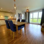 Spacious modern kitchen and dining area with wooden flooring.