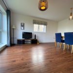 Modern living room with wood floor and dining area.