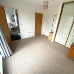 Empty bedroom with ensuite and wardrobes.