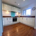 Modern kitchen with wooden flooring and cabinets