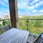 Modern balcony view of park and buildings.