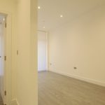 Empty room with wooden floor and open door.