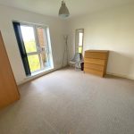 Empty room with window, dresser, and chair.