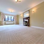 Spacious living room with fireplace and large window.
