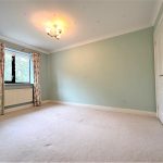 Empty room with light green walls and floral curtains.