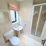Modern bathroom with shower, sink, and toilet.