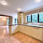 Spacious kitchen with tiled floors and large windows.