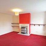 Living room with red carpet, fireplace.