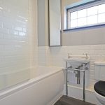 Modern bathroom with bathtub, sink, and toilet.