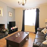 Cosy living room with sofa and fireplace.