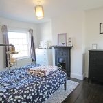 Cosy bedroom with fireplace and patterned bedding.