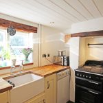 Cosy cottage kitchen with wooden countertops and range cooker.