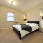 Modern bedroom with double bed and stylish decor.