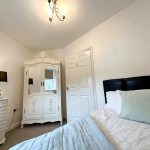 Bright bedroom with vintage wardrobe and cosy bed.