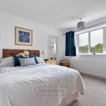 Cosy bedroom with double bed and blue curtains.